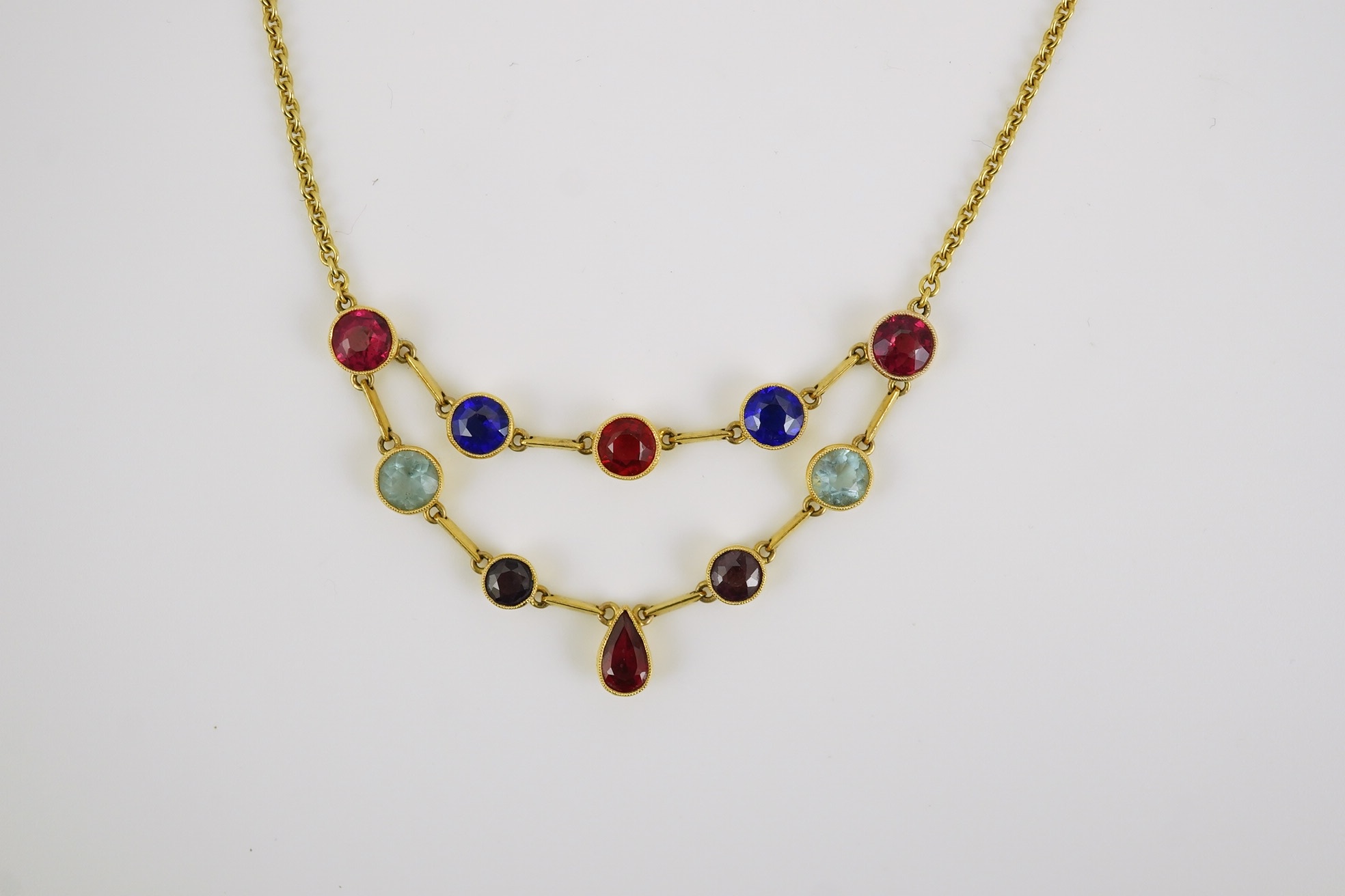 An early 20th century 15ct gold and ten stone multi coloured doublet set necklace